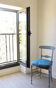 罗宾鲁伯龙Gîte de l'Escanson un temps pour soi的窗前的蓝色椅子