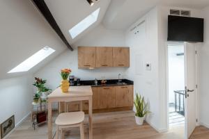 安特卫普Miniloft Pelgrim的厨房配有木制橱柜和桌椅