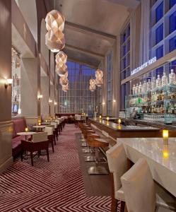 萨克拉门托萨克拉门托凯悦丽景酒店的餐厅设有酒吧和桌椅