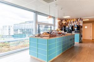 洛桑B&B HOTEL Lausanne Crissier的一间设有蓝色橱柜和大窗户的厨房
