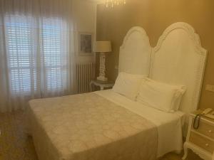 圣巴特罗摩艾美尔Hotel Bergamo Mare Mhotelsgroup的卧室配有白色大床和白色枕头