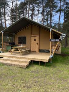 索尔陶Glampingzelt Family - Lodge的小屋设有木门廊和野餐桌