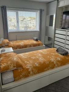 特雷杜尔Garreg Fawr Trearddur Bay - Ty Melyn的一间卧室配有两张床和镜子