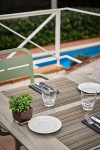 圣安德烈斯-德拉巴尔卡加泰罗尼亚布里斯托尔酒店的桌子上放有盘子和玻璃杯,上面放有植物