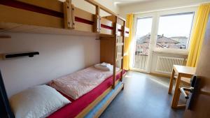 洛迦诺洛迦诺青年旅舍的一间带两张双层床的卧室和一个阳台