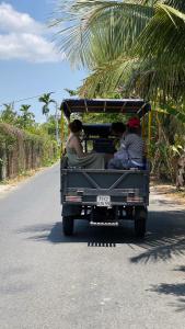 Ấp Phú Hòa (3)Hide Away Bungalows in Ben Tre City的一群人乘坐卡车沿着公路行驶