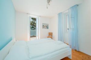 布里萨戈Brissago Lake Apartment的白色的卧室设有床和窗户