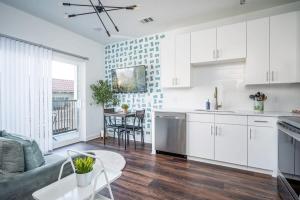 亚特兰大Luxe 1BR w Balcony in Downtown 542Blvd206的厨房以及带白色橱柜和桌子的客厅。