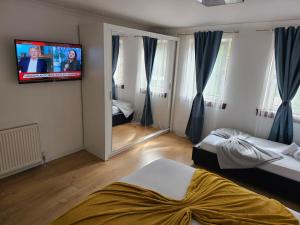 格拉斯哥Modern house close to Glasgow Green的一间卧室设有两张床,墙上配有电视。
