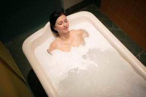 巴甫洛夫Wellness Hotel IRIS的女人坐在浴缸里