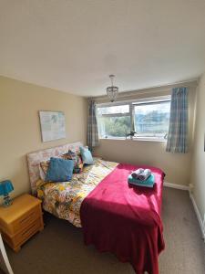布里德波特58 Magdalen Lane的一间卧室配有一张带红色毯子的床和窗户。