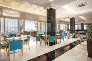 卡尔扎迈纳大蓝海滩酒店 的一间带桌椅的餐厅和一个大堂