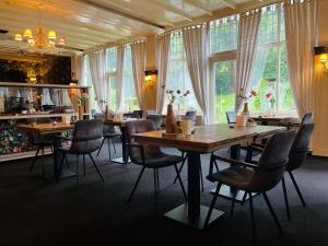 宁斯佩特文宁达尔别墅庄园酒店的用餐室设有桌椅和窗户。
