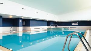 波特劳伊斯波特劳伊斯凯拉申酒店的拥有蓝色和白色墙壁的大型游泳池