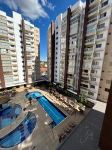 阿西斯Caldas Novas - Condominio Casa da Madeira - ate 5 pessoas - PERMITIDO descer com bebida para o parque - Centro的大楼前游泳池的顶部景色