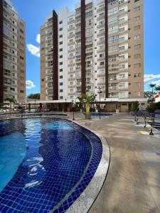 阿西斯Caldas Novas - Condominio Casa da Madeira - ate 5 pessoas - PERMITIDO descer com bebida para o parque - Centro的一个大型游泳池,其背后是高大的建筑