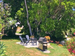 Las Lagunas MijasSpanish charm guest apartment at villa with great location!的庭院里设有椅子和烧烤架