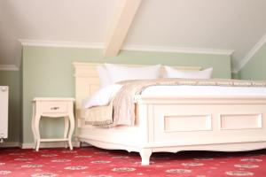 斯基希德尼萨СПА-Готель "RESPECT"的卧室配有白色的床和红色地毯