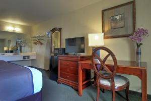 罗宾逊维勒Key West Inn - Tunica Resort的酒店客房配有一张书桌、一台电视和一张床