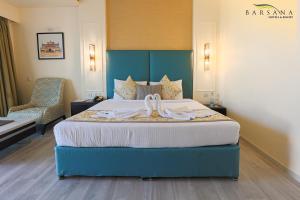 西里古里Barsana Hotel & Resort Siliguri的酒店客房,配有一张带弓的床铺