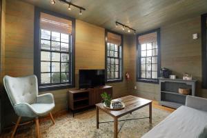 查尔斯顿Revitalized Historical Southern Residence的客厅配有电视、椅子和桌子