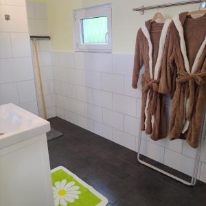 SchweiFerienwohnung mit Wellness & Radverleih的浴室拥有白色瓷砖墙壁和棕色毛巾。