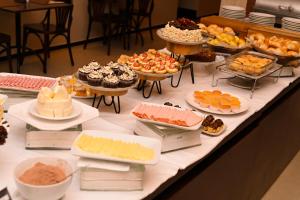 乌贝兰迪亚Gran Executive Hotel的一张桌子,上面摆放着各种蛋糕和糕点