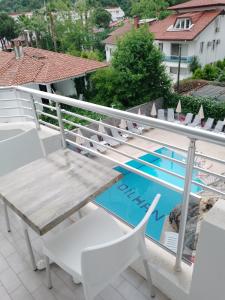 马尔马里斯Dilhan Hotel的游泳池旁的甲板上配有桌椅