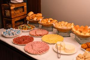 乌贝兰迪亚Gran Executive Hotel的一张桌子,上面放着不同类型的面包和馅饼