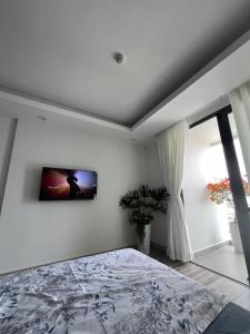 Ấp Rạch MẹoStudio Sofia Center的卧室配有一张床,墙上配有电视。