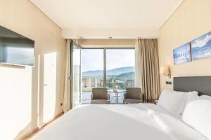 雅典雅典门酒店的酒店客房设有一张床和一个大窗户
