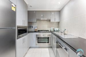 悉尼Aircabin - Meadowbank - Waterview - 3 Beds Apt的厨房配有白色橱柜和水槽