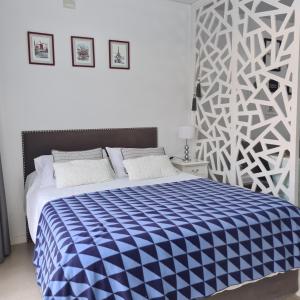 蒂格雷Departamentos Condominio Wyndham Nordelta - Desayuno y Spa Opcional !的一间卧室配有一张带蓝白色毯子的床