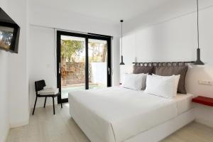 玛利亚MichELe Luxury apartments by Smaris Collection的白色卧室配有一张白色的大床和一把椅子