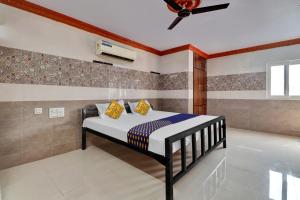 OngoleSPOT ON Hotel Maha Lakshmi的一间卧室配有一张床和吊扇