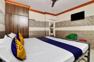 OngoleSPOT ON Hotel Maha Lakshmi的卧室配有一张床,墙上配有电视。
