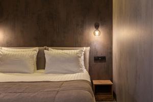 斯基希德尼萨Phoenix Medical Resort的一间卧室配有带白色枕头和灯的床