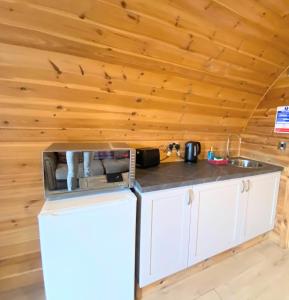 KeltyPond View Pod 1 with Outdoor Hot Tub - Pet Friendly - Fife - Loch Leven - Lomond Hills的小屋内的厨房配有冰箱和水槽