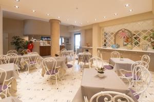 维亚雷焦圣弗朗西斯科酒店的一间设有白色桌子和白色椅子的餐厅