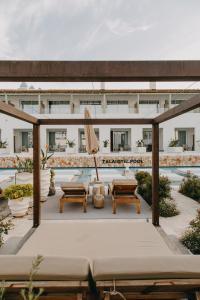 卡兰博希Lago Resort Menorca - Suites del Lago Adults Only的一座建筑顶部的庭院,配有椅子和遮阳伞