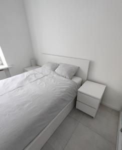 华沙Apartament w samym centrum的一间白色卧室,配有床和2个床头柜