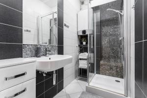 格但斯克Apartament Świętego Ducha 3234的黑白浴室设有水槽和淋浴