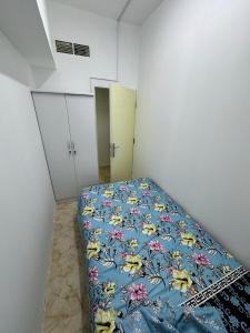 沙迦Al Majaz Partition & Rooms的一间卧室配有一张带蓝色花卉棉被的床