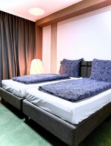 汉堡Hotel Hamburg Inn的一间卧室配有两张带紫色枕头的床