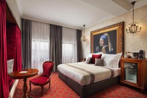 布达佩斯Mystery Hotel Budapest的酒店客房,配有床、桌子和椅子