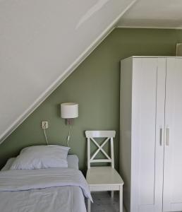 WoudsendDe Rakken的一间卧室配有床和白色橱柜