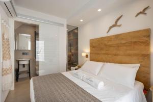 莫诺波利WePuglia - Vista Cattedrale的卧室配有白色的床和木制床头板