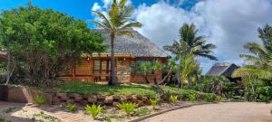 Miramar海湾景致山林小屋的茅草屋顶和棕榈树度假屋