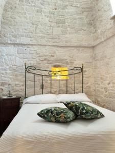 阿尔贝罗贝洛Trulli Aia Piccola的一间卧室配有一张带枕头的床
