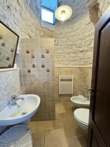 阿尔贝罗贝洛Trulli Aia Piccola的浴室设有2个水槽和2个卫生间